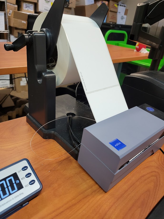 A Rollo label printer with a stand for holding the labels.