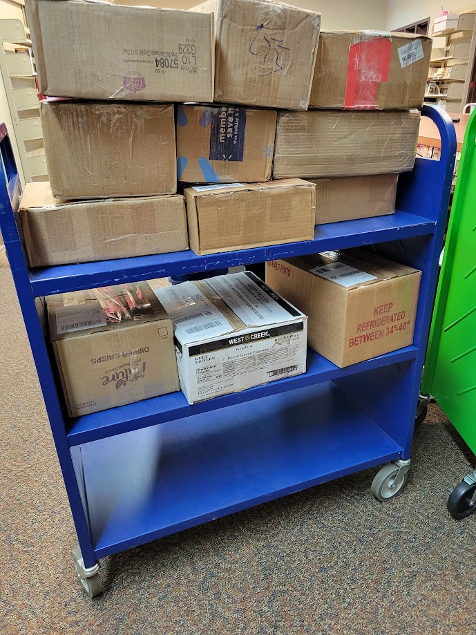The blue, extra wide library cart now filled with boxes.